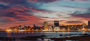 Montevideo Uruguay skyline at sunset with waterfront, representing SA, SRL, SAS and branch office corporate structures in Uruguay.