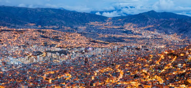 Twinkling La Paz valley skyline at dusk, mirroring Bolivia’s layered business entities like SRL, SA corporate structures.