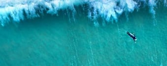 Surfer in green ocean denoting JPFs offering